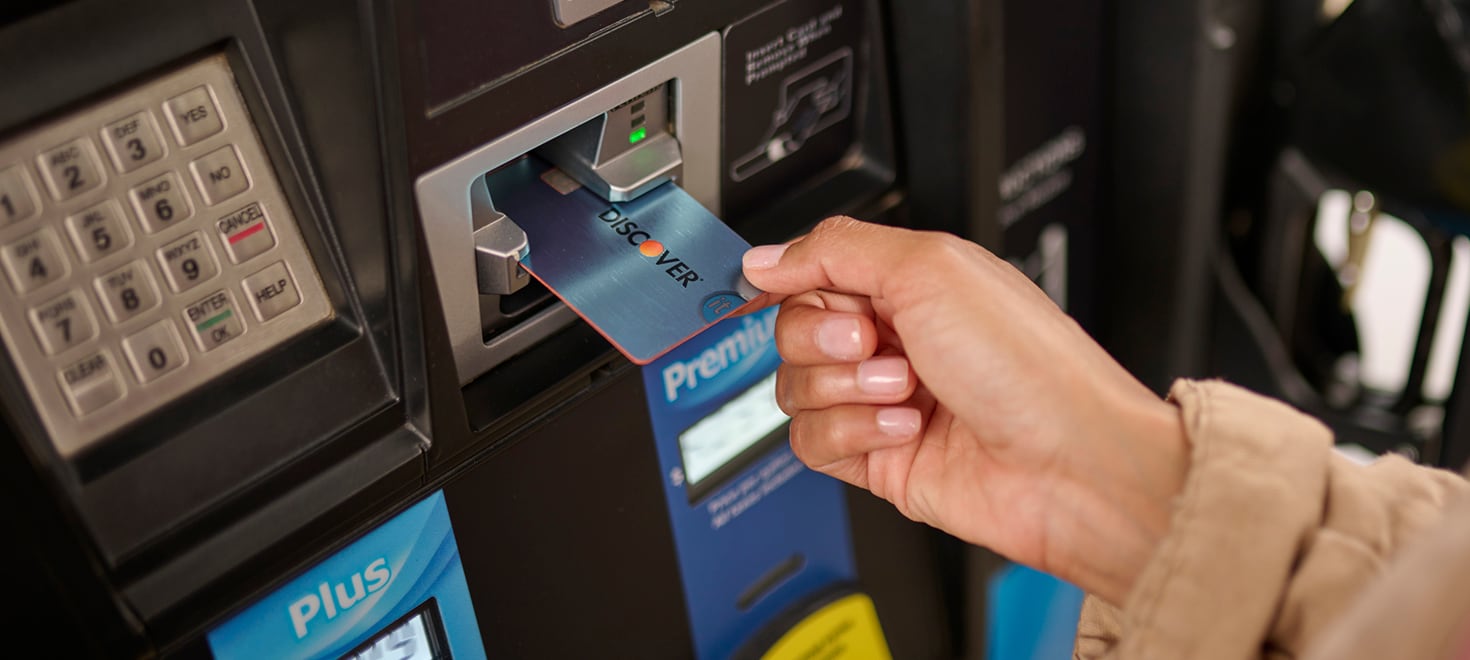 person using discover card at fuel dispenser
